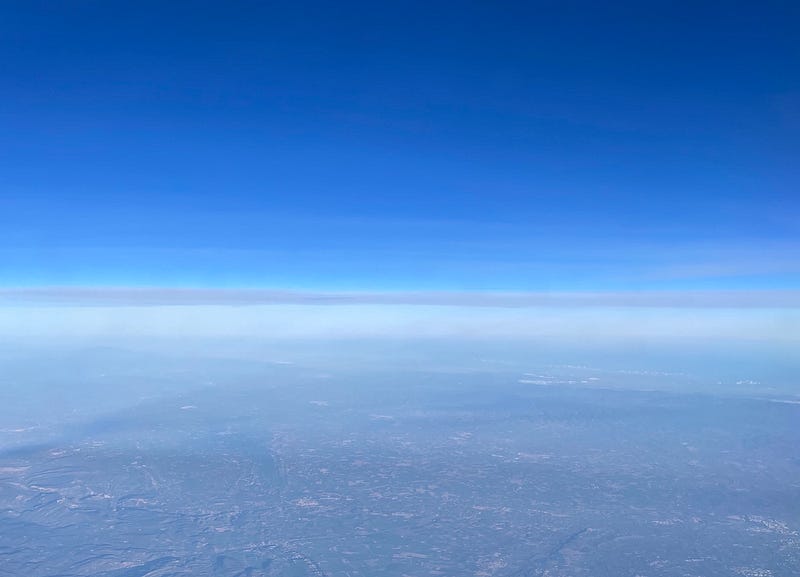 Blue sky above the cloud line with the earth far below.